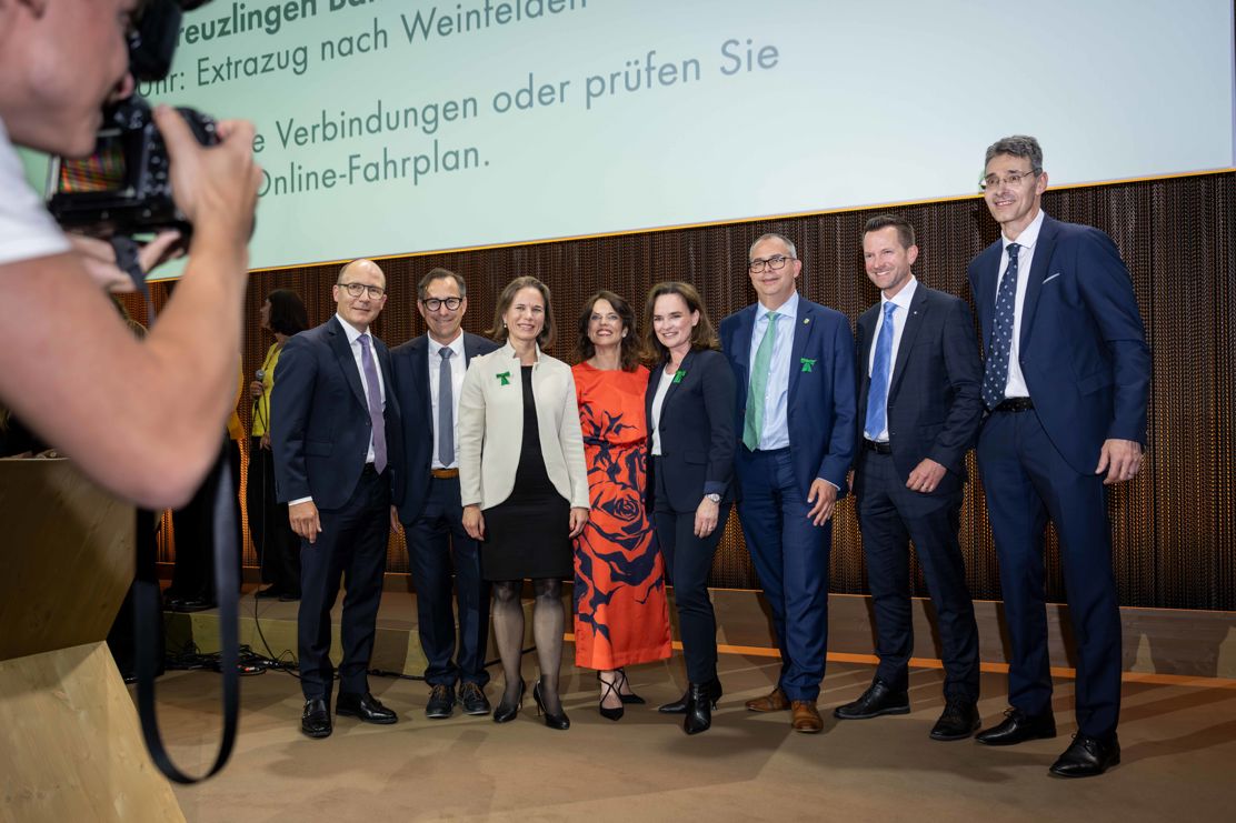 Bankvertreter und Gäste posieren mit Moderatorin Mona Vetsch für ein Gruppenbild.