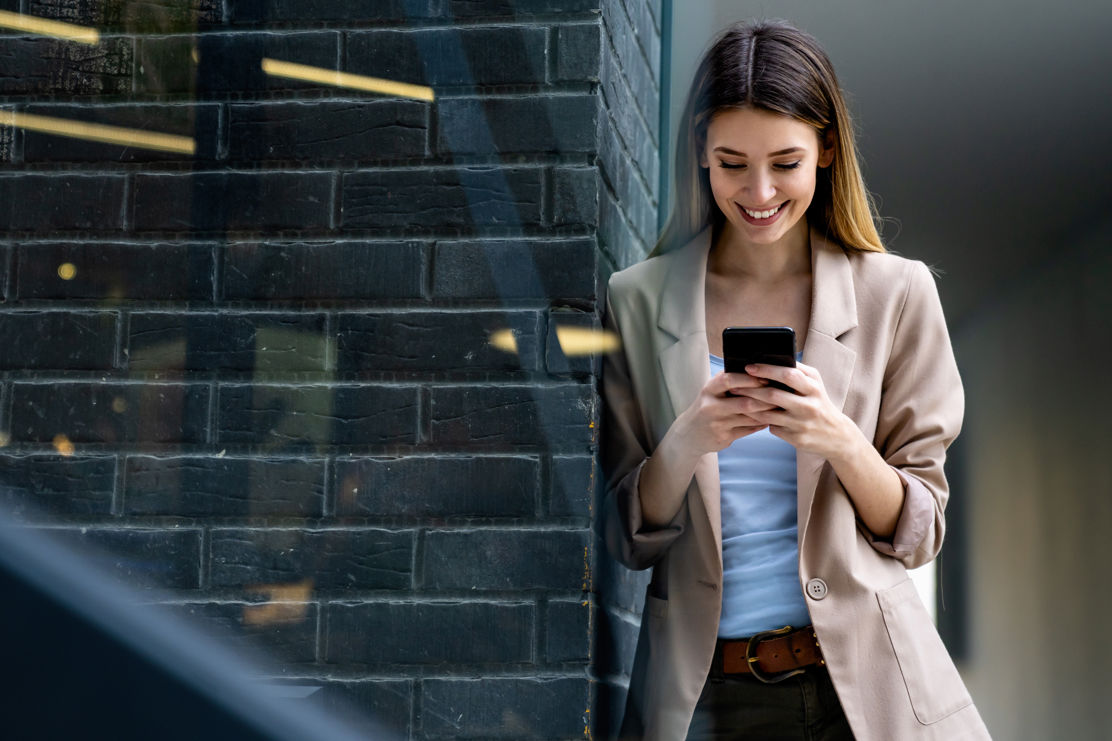 Frau am Smartphone eröffnet Anlagekonto, welches Vorzugszinsen bietet.